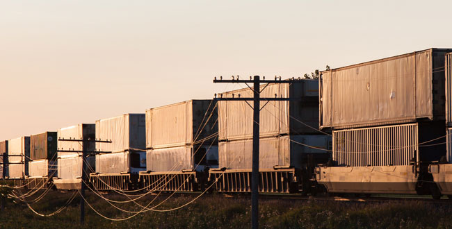 Train cars driving in the sunset.
